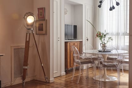 El comedor está conectado con el living, pero la parte más iluminada. La eleccipon de las cortinas de gasa y las sillas transparentes aumenta la levedad general