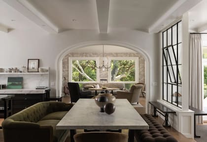 El comedor no usa sillas y acerca a la mesa un sillón de varios cuerpos y una extensa banqueta