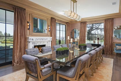 El comedor, para doce comensales, tiene grandes ventanales con vista al extenso jardín.