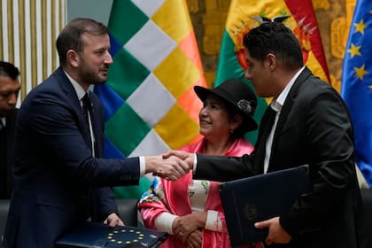 El Comisario de Medio Ambiente, Océanos y Pesca de la Unión Europea, Virginijus Sinkevicius, a la izquierda, estrecha la mano del ministro de Medio Ambiente y Agua de Bolivia, Alan Lisperguer, mientras la Ministra de Asuntos Exteriores de Bolivia, Celinda Sosa, observa durante una ceremonia para firmar un acuerdo de financiación relacionado con el clima en La Paz, Bolivia, el lunes 18 de marzo de 2024. (AP Foto/Juan Karita)