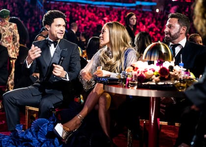 El conductor Trevor Noah sentado junto a Jennifer Lopez y Ben Affleck