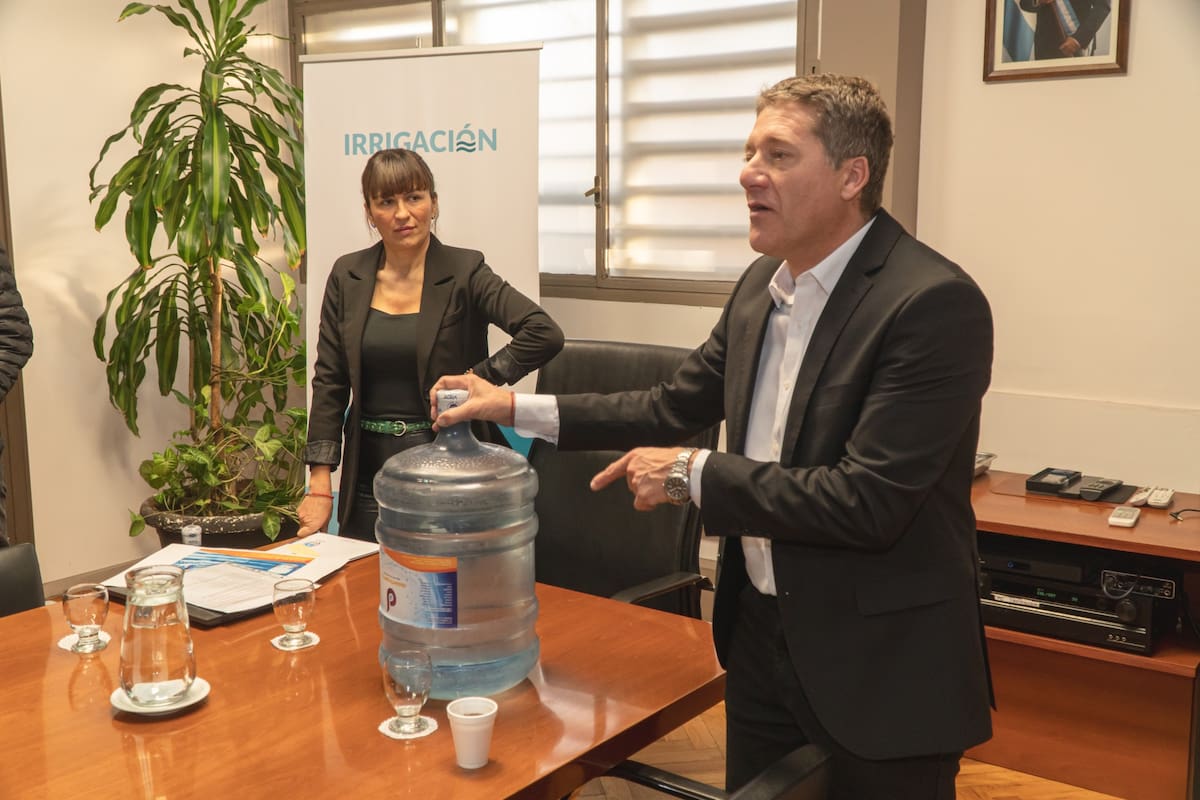 El Consejero del Río Atuel, Gustavo Villegas, exhibe el botellón de agua que, dijo, venden en La Pampa a otras provincias