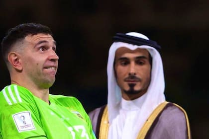 El criticado gesto de Emiliano "Dibu" Martínez luego de recibir el trofeo al mejor arquero del Mundial Qatar 2022; detrás, el emir del país organizador.