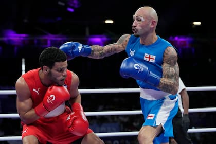 El cubano Erislandy Álvarez, de rojo, en su semifinal de peso ligero de Juegos Olímpicos ante el georgiano Lasha Guruli, el domingo 4 de agosto de 2024, en Villepinte, Francia. (AP Foto/Ariana Cubillos)