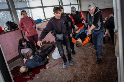 El cuerpo de un hombre yace en el suelo de una estación de subte en Kharkiv, tras un ataque ruso.  (AP Photo/Bernat Armangue)