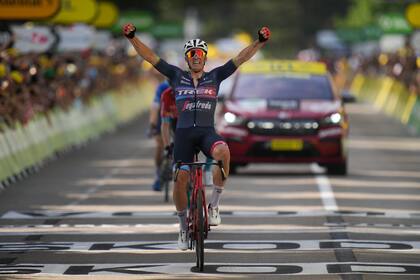 El danés Mads Pedersen levanta los brazos al cruzar victorioso la meta en la 13ra etapa del Tour de Francia, tras dejar atrás a dos compañeros de fuga en la acelerada final el 15 de julio del 2022 en Saint-Etienne. (AP Photo/Daniel Cole)