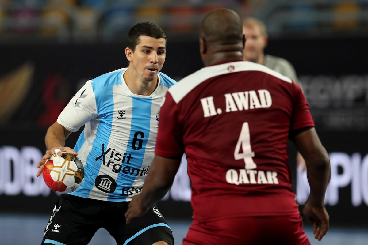 El defensa central argentino Diego Simonet (izq.) Es cerrado por el pivote de Qatar Hassan Mabrouk (der.) Durante el partido del Campeonato Mundial Masculino de Balonmano 2021 entre los equipos del Grupo II Argentina y Qatar en el estadio de deportes de El Cairo en la capital egipcia el 25 de enero