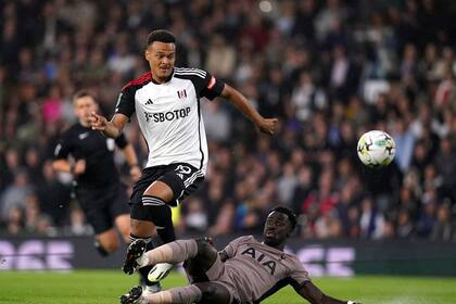El defensa colombiano Davinson Sánchez del Tottenham Hotspur disputa el balón ante Rodrigo Muniz del Fulham (izquierda), durante el partido de la 2da ronda de la Copa de la Liga en Craven Cottage, Londres. Martes 29 de agosto de 2023. (John Walton/PA via AP)