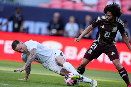 El defensa uruguayo Nahitan Michel, izquierda, roba el balón al mexicano César Huerta en la primera mitad durante el primer tiempo del partido amistoso, de preparación rumbo a la Copa América, entre las selecciones de Uruguay y México, el miércoles 5 de junio de 2024, en Denver. (AP Foto/David Zalubowski)