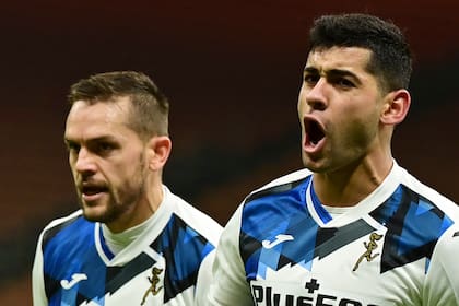 El defensor argentino del Atalanta, Cristian Romero (derecha), celebra tras abrir el marcador durante el partido de fútbol de la Serie A italiana AC Milan vs Atalanta Bergamo el 23 de enero de 2021 en el estadio de San Siro en Milán.