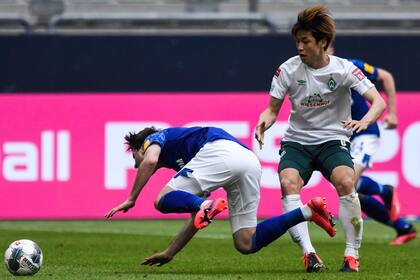 El defensor español del Schalke, Juan Miranda (L) compite por el balón con el delantero japonés del Bremen Yuya Osako durante el partido de fútbol de la Bundesliga de la primera división alemana FC Schalke 04 v SV Werder Bremen el 30 de mayo de 2020 en el Veltins Arena en Gelsenkirchen,