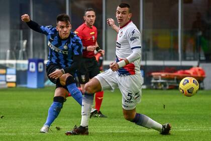 El delantero argentino del Inter de Milán Lautaro Martínez patea para anotar un gol junto al defensor serbio de Crotone Vladimir Golemic durante el partido de fútbol de la Serie A italiana Inter de Milán vs Crotone el 3 de enero de 2021 en el estadio Giuseppe-Meazza de Milán.