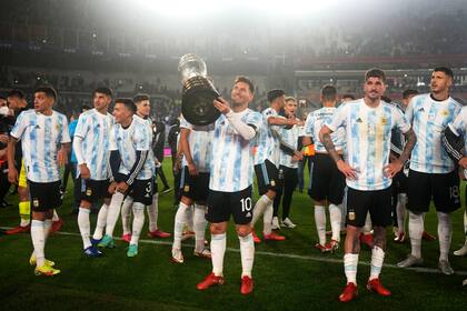El delantero argentino Lionel Messi (centro) alza el trofeo de la Copa América tras el término del partido contra Bolivia por las eliminatorias del Mundial, el jueves 9 de septiembre de 2021, en Buenos Aires. (AP Foto/Natacha Pisarenko, Pool)
