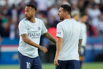 El delantero argentino Lionel Messi (derecha) y su compañero brasileño Neymar del Paris Saint-German durante el calentamiento previo a un partido de la liga francesa contra Montpellier, el sábado 13 de julio de 2022. (AP Foto/Francois Mori)