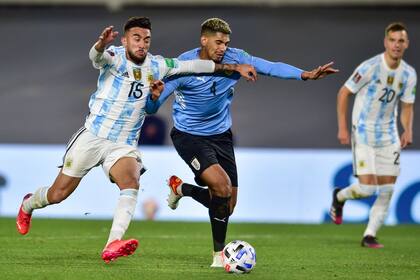 El delantero argentino Nicolás González (izquierda) disputa el balón con el defensor uruguayo Ronald Araujo en el partido por las eliminatorias mundialistas, el domingo 10 de octubre de 2021, en Buenos Aires. (AP Foto/Gustavo Garello)