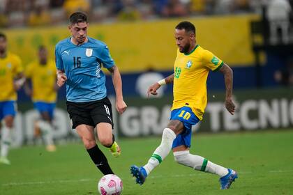 El delantero brasileño Neymar, derecha, y el uruguayo Federico Valverde disputan el balón en un duelo de las eliminatorias sudamericanas para la Copa del Mundo Qatar 2022 en Arena da Amazonia de Manaos, Brasil, el jueves 14 de octubre de 2021. (AP Foto/Andre Penner)