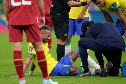 El delantero brasileño Neymar recibe tratamiento durante el partido contra Serbia por el Grupo G del Mundial, el jueves 24 de noviembre, en Lusail, Qatar. (AP Foto/Andre Penner)