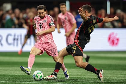 El delantero de Inter Miami Lionel Messi (10) lucha por el balón contra el mediocampista del Atlanta United Bartosz Slisz (derecha), durante la primera mitad de un partido de la MLS, el domingo 16 de marzo de 2025, en Atlanta. (AP Foto/Colin Hubbard)