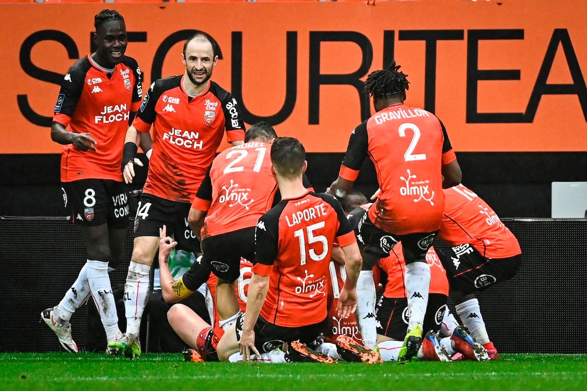 El delantero francés de Lorient, Yoane Wissa (tapado) celebra con sus compañeros de equipo tras marcar un gol durante el partido de fútbol francés L1 entre el FC Lorient y el Paris Saint-Germain en el estadio Stade Yves-Allainmat, en Lorient, en el oeste de Francia, el 31 de enero de 2021.