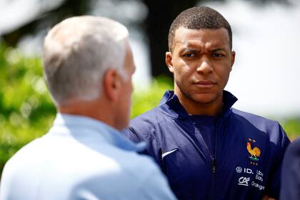 El delantero francés Kylian Mbappé escucha al técnico Didier Deschamps. (Sarah Meyssonnier/Pool Foto vía AP)