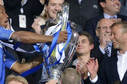El delantero marfileño Drogba le ofrece la Champions al ruso Román Abramóvich, el primer magnate que desembarcó fuerte en el fútbol en los albores del siglo XXI; en 2003 desembolsó 200 millones de euros por el club de Londres