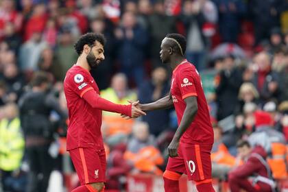 El delantero Mohamed Salah (izquierda) saluda a su compañero Sadio Mané en el partido de su club Liverpool ante Watford en la Liga Premier, el 2 de abril de 2022. (AP Foto/Jon Super)