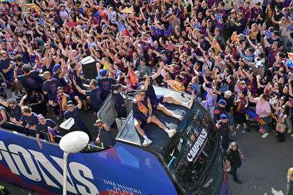 El delantero polaco de Barcelona, Robert Lewandowski, saluda junto a sus compañeros mientras se detiene en un autobús para celebrar la consecución del 29º título de liga española
