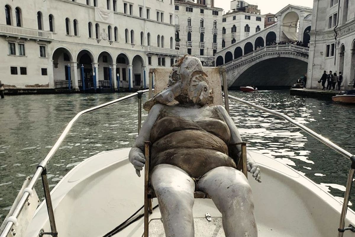 El desafiante traslado por los canales de Venecia de "La Bagnante", de Luigi Citarrella, una mujer con cabeza de motor