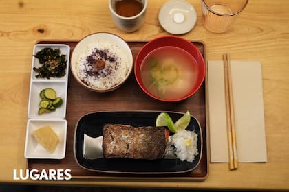 El desayuno incluye un pescado, una sopa de miso, pepino en pickle, huevo tamago, ensalada de algas y umeboshi con té verde