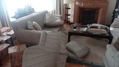 El desorden del living del primer piso de la casa del matrimonio Del Rio; detrás del sillón de la izquierda se ven las cajas embaladas por la pronta mudanza; junto al sillón de la derecha se encontró el casquillo de una bala