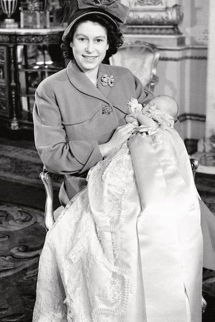 El día de su bautismo, vestido con la túnica de encaje Honiton heredada de la reina Victoria y en brazos de su madre, la entonces princesa Isabel.