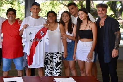 El Diablito Echeverri celebra la firma de su contrato con su familia y su representante, Enzo Montepaone, a la derecha