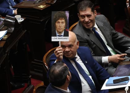 El diputado Aldo Leiva sostiene un cartel con el rostro de Milei y la leyenda: I love Margaret, por Thatcher la exprimera ministra del Reino Unido durante la guerra de Malvinas