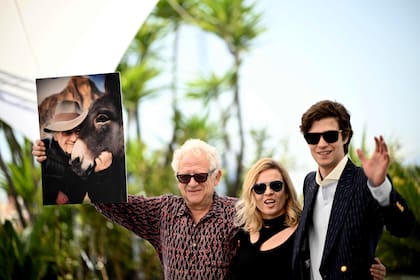 El director polaco Jerzy Skolimowski levanta una foto en la que se ve a un burro, el protagonista de su película en competencia en Cannes; junto al director, la productora y guionista Ewa Piaskowska y el actor Lorenzo Zurzolo