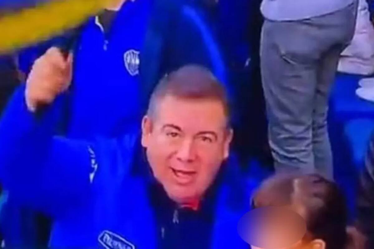 El dirigente de Atlético Tucumán, Miguel Abbondándolo, flamea una bandera de Boca en la despedida de Riquelme