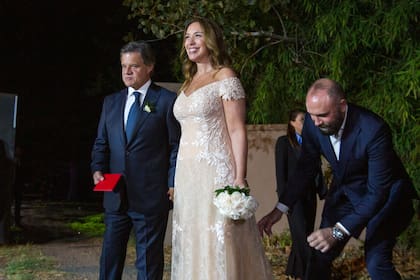 El diseñador Gabriel Lage arregla la cola del vestido de María Eugenia Vidal, mientras los novios salen a saludar a los periodistas que montan guardia en la tranquera de la estancia. El periodista y la exgobernadora quisieron mantener la celebración bien íntima. Es por eso que no hubo lista de regalos ni invitaciones papel. Las realizaron ellos mismos vía mails y mensajes de WhatsApp
