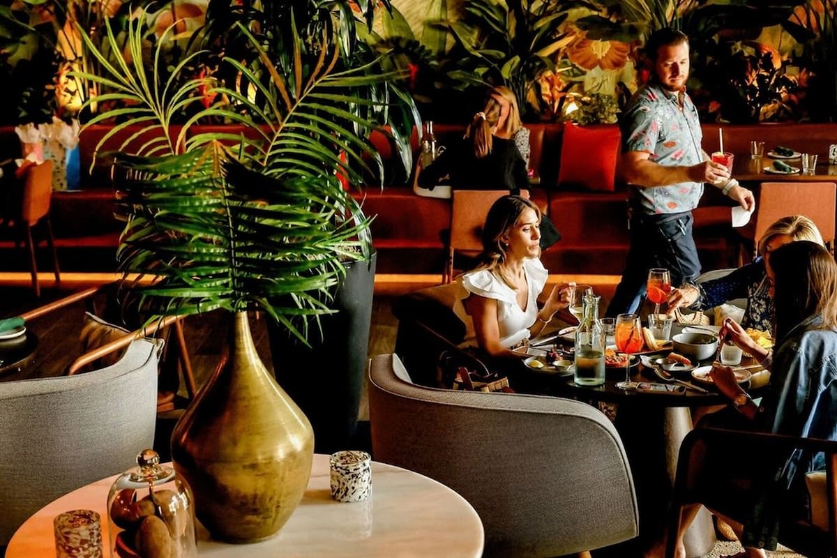 El diseño de interiores crea un ambiente tropical rodeado de vegetación natural y luces cálidas