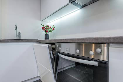 El diseño minimalista de esta cocina integra el lavavajillas de forma discreta, maximizando el espacio y manteniendo una estética coherente.
