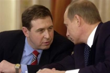 El doctor Andrei Illarionov (izq.) observa al presidente Putin, durante un discurso