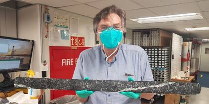 El doctor Andrew McCaig sostiene una sección larga de roca del manto de la Tierra