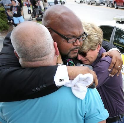 El dolor: un religioso consuela a una funcionaria del gobierno de Orlando y a un abogado de los derechos de los gays