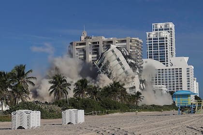 El domingo 13 de noviembre de 2022 la torre del hotel de 17 pisos del histórico Deauville Beach Resort implosiona arrojando una gran cantidad de polvo y escombros a los edificios de lujo situados junto al océano. (Carl Juste/Miami Herald vía AP)
