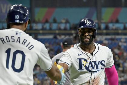 El dominicano de los Rays de Tampa Bay Amed Rosario felicita a su compañero Yandy Diaz después de que anotó ante el abridor de los Yankees de Nueva York el martes 9 de julio del 2024.. (AP Foto/Steve Nesius)