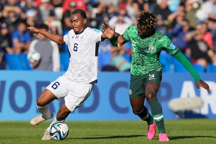 El dominicano Israel Boatwright (izquierda) y el nigeriano Abel Ogwuche pugnan por el balón en el partido del Mundial Sub20, el domingo 21 de mayo de 2023, en Mendoza, Argentina. (AP Foto/Natacha Pisarenko)