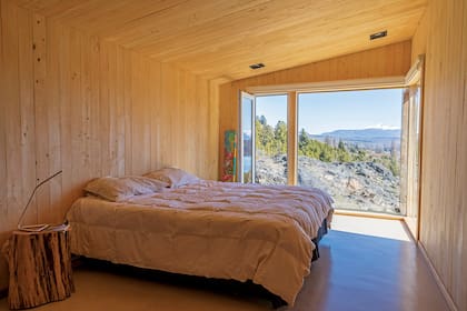 El dormitorio, de líneas simples, no necesita mucha más que la vista.