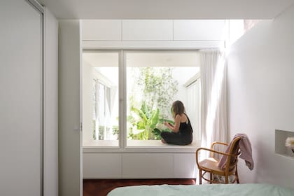 El dormitorio está conectado al patio a través de un gran ventanal. Además, comparten los beneficios de la profunda cajonera, que en el exterior actúa como banco generoso.