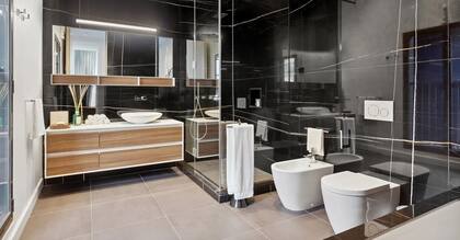 El dormitorio principal cuenta con un espectacular baño de mármol con una ducha con mampara de vidrio y una claraboya.