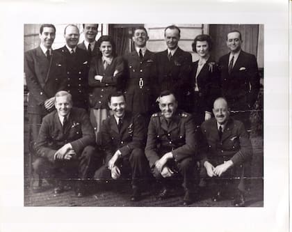 El Dr. Miguel Ángel Cárcano junto a su esposa Stella Maria Carlota Morra Victorica, bisnieta de Justo José de Urquiza. Su hija Stella Ana (brazos cruzados), llevando en su prenda un broche de la RAF, personal de la embajada y voluntarios argentinos fotografiados en Londres durante 1943. (Archivo Claudio Meunier)
