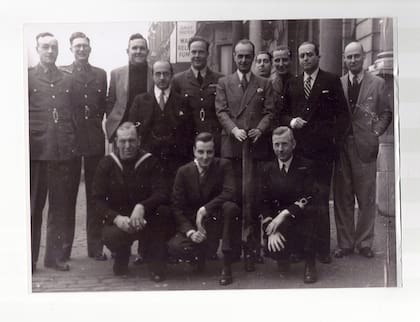 El Dr. Miguel Ángel Cárcano y voluntarios argentinos posan junto con los restos de la bomba alemana que explotó en el exterior de la Embajada Argentina en Londres. (Archivo Claudio Meunier).