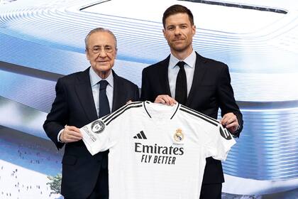 El DT Xabi Alonso posa junto a Florentino Pérez y la camiseta de Real Madrid